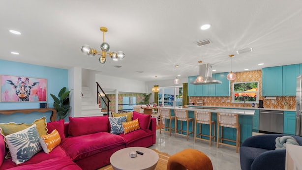 A modern living room with a red sofa, a round coffee table, and a blue armchair.