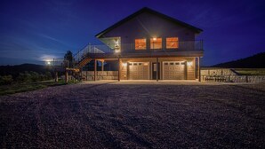 Une maison à deux étages avec un balcon, un garage et une allée.