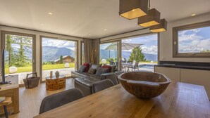 Una cucina moderna con ampie finestre, un tavolo da pranzo in legno e vista sulle montagne.