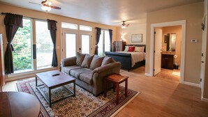 A spacious living area with a sofa, coffee table, and a view of the outdoors through large windows. - Jacksonville Towne Square.  (Jacksonville)