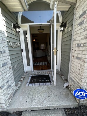 A house entrance with a welcome sign, a doormat, and a security sign. - 3 bedroom, private heated pool, hot tub & less than 20 minutes from the beaches! (Longs)