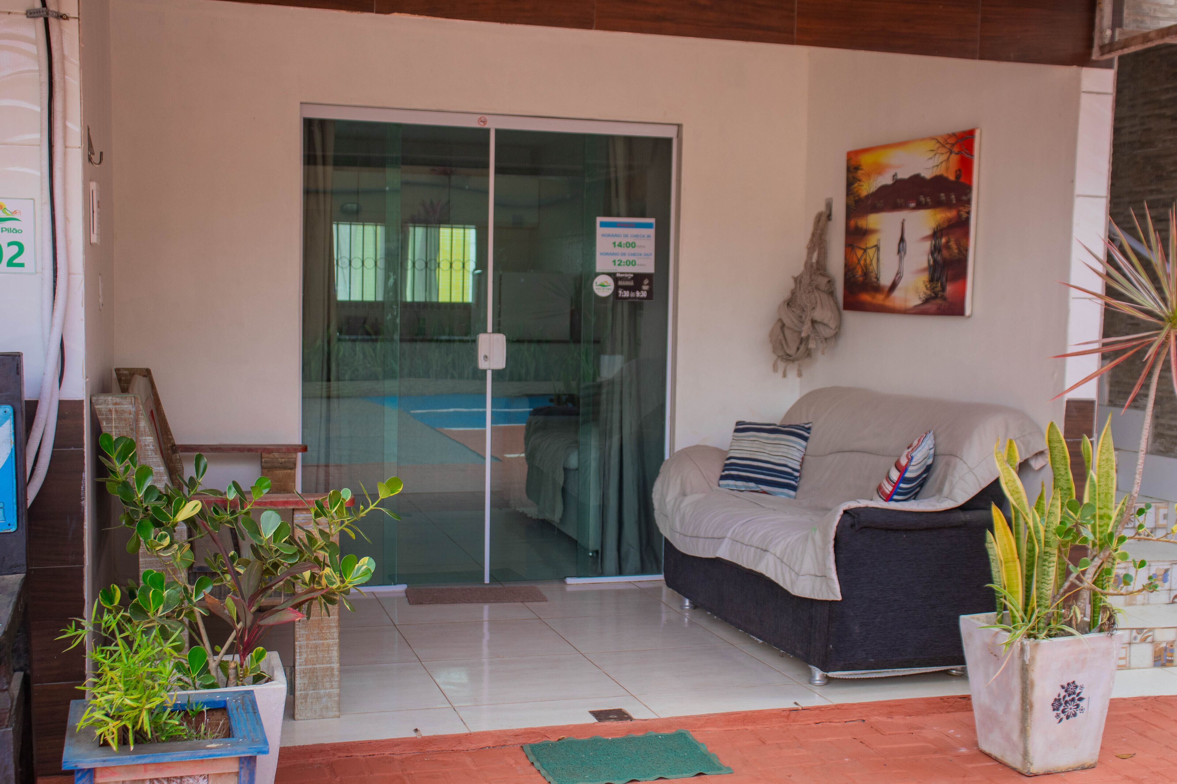 A reception area with a glass door, a sofa, and potted plants.