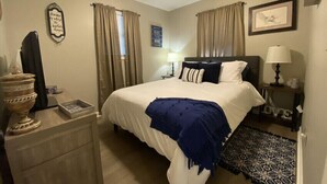 A bedroom with a bed, a ceiling fan, a dresser, a nightstand, and a rug. - Uncork, Unwind, Relax @ this Family & pet Friendly Lake Home #1 (Martin)
