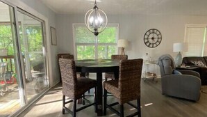 A spacious living room with a dining area, large windows, and a chandelier. - Uncork, Unwind, Relax @ this Family & pet Friendly Lake Home #1 (Martin)