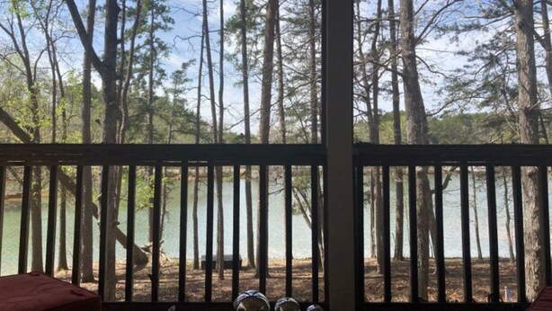 A room with a large window overlooking a forested area and a body of water. - Uncork, Unwind, Relax @ this Family & pet Friendly Lake Home #1 (Martin)