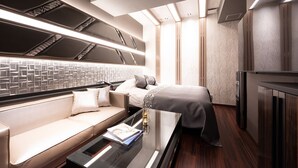 A modern, well-lit bedroom with a sofa, a bed, and a glass table. - HOTEL K-NEXT (Saitama)
