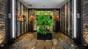A modern hotel lobby with a central planter, marble walls, and a zebra-patterned design. - HOTEL K-NEXT (Saitama)
