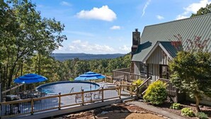 Un espace piscine doté d’une terrasse en bois, de chaises longues et d’un jacuzzi.