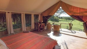 A tented room with a bed, a small table, and chairs. There is a view of a grassy area outside. - Ekorian's Mugie Camp (Sukuta Mugie)
