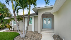 A house with a light blue door, a white exterior, and a small front porch.