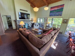 Una sala de estar acogedora con un sofá grande, una chimenea y un televisor.