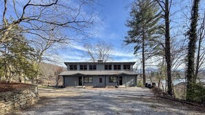 A two-story building with a gravel driveway and stone wall.