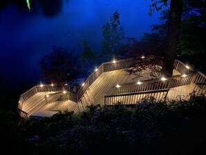 Eine Holzterrasse mit gewundener Geländer, umgeben von Pflanzen.