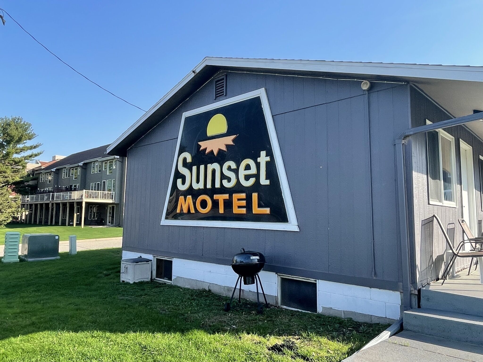 Motelbordje met een zon en berg afbeelding, wat duidt op een mogelijke buiten- of landschapslocatie.