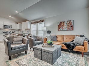 A modern living room with a sofa, armchairs, and a coffee table.