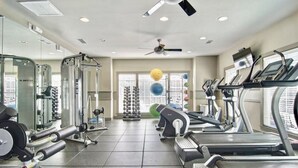A gym with treadmills, weight machines, and exercise balls.