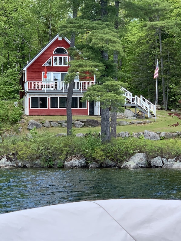 A two-story house with a red exterior and white trim, located near a body of water with a dock. - Charming 3 bedroom on Beech Hill Pond close to Ellsworth and Bar Harbor WiFi, AC (Otis)
