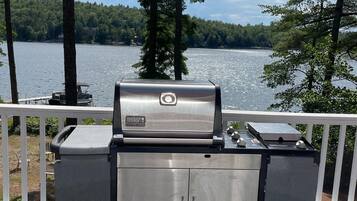 Ein Weber-Grill mit Blick auf einen See und einen Wald.