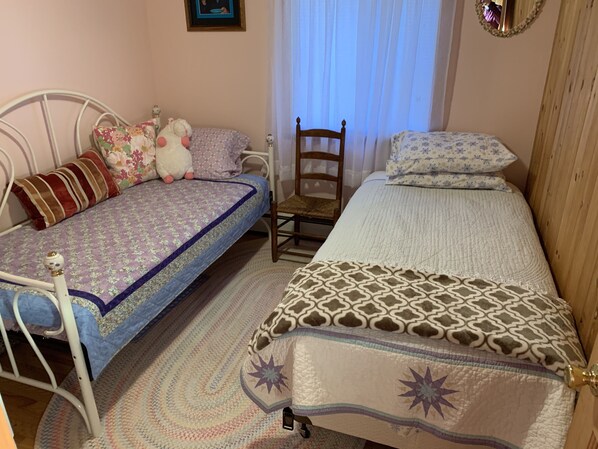 A bedroom with two single beds, a wooden chair, a small table, and a mirror on the wall. - Charming 3 bedroom on Beech Hill Pond close to Ellsworth and Bar Harbor WiFi, AC (Otis)