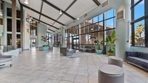 A spacious lobby with a high ceiling, large windows, and modern seating areas. - LUXURY PHOENIX UNIT, GREAT FOR FAMILIES, TONS OF AMENTIES (Orange Beach)