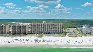 A beachfront hotel with multiple buildings, a sandy beach, and a clear sky. - LUXURY PHOENIX UNIT, GREAT FOR FAMILIES, TONS OF AMENTIES (Orange Beach)