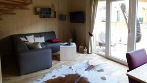 Een moderne woonkamer met een bank, een salontafel en een groot raam.
