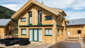 Une cabane en bois dotée d’un balcon, d’une terrasse et d’un espace sauna.