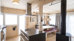 Une cuisine moderne avec des éléments en bois, un îlot central et une cuisinière intégrée.