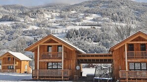 A wooden cabin with a balcony, set against a snowy mountainous backdrop. - mit 4 Schlafzimmern & IR-Sauna by Interhome (Sankt Georgen am Kreischberg)