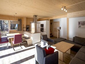 A modern cabin interior with a dining area, kitchen, and living space.