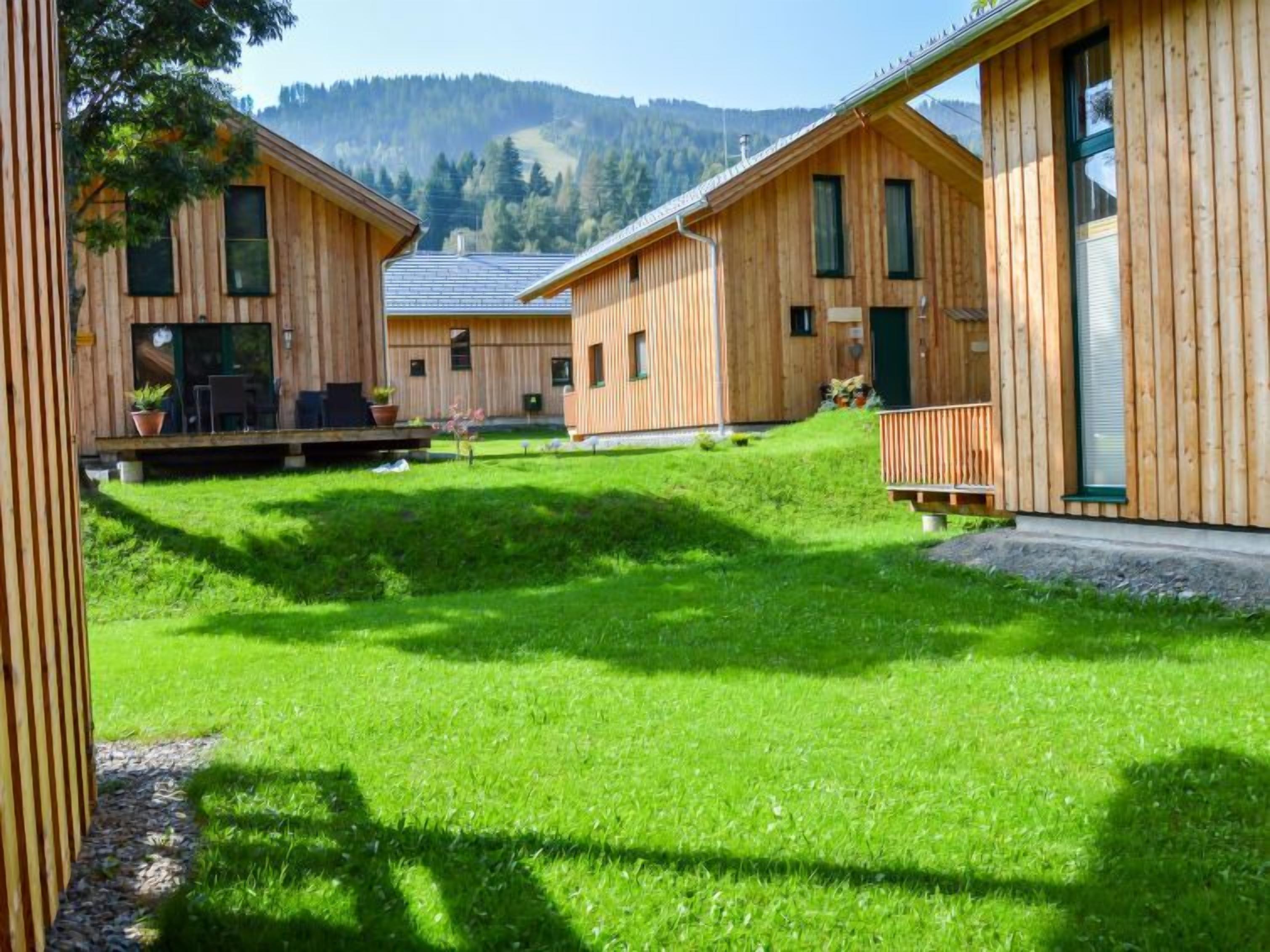 Eine Holzhütte mit Rasen und Bergblick.