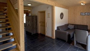 Ein Holzinnenraum mit einer Treppe, einem Sofa und einem Schild mit der Aufschrift 'HOME'.