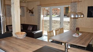 Una cocina moderna con encimera de madera, un lavamanos y una zona de comedor con sillas y una mesa.