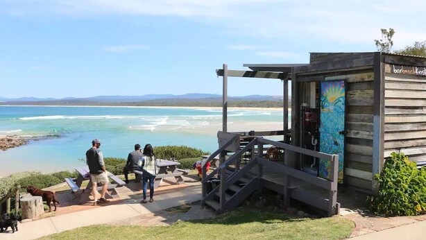 A coastal view with a wooden structure, a staircase, and a bench area overlooking the beach. - Cordova - Perfect Summer or Winter Getaway (Merimbula)