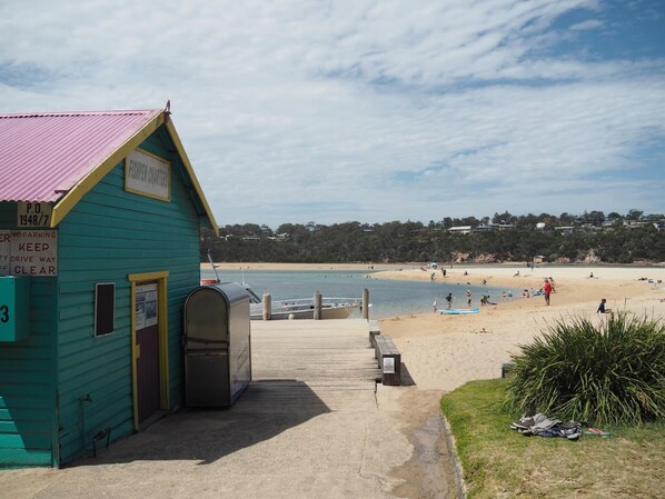 A turquoise building with a pink roof, a sign reading "P.O. Box 1948/7", and a bench in front. - Cordova - Perfect Summer or Winter Getaway (Merimbula)