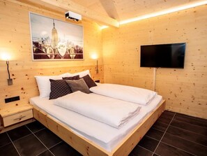 Relax in this serene bedroom with a large bed, bedside tables, and a flat-screen TV.