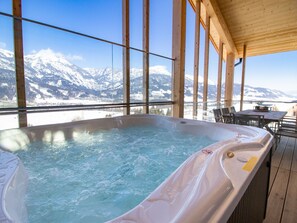 A hot tub with a view of snow-capped mountains.