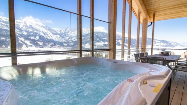 A hot tub with a view of snow-capped mountains.