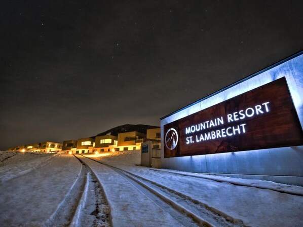 Une enseigne indiquant le complexe touristique de montagne de St. Lambrecht, avec un bâtiment moderne en arrière-plan.