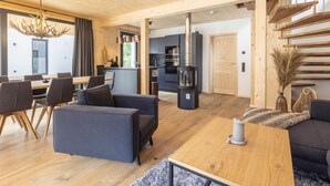Een moderne woonkamer met een eethoek, een keuken en een trap.