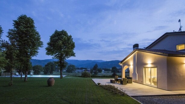 Uma casa moderna com um pátio e vista para o campo.