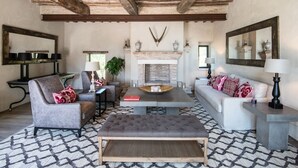 A living room with a fireplace, a sofa, a chair, a coffee table, and a patterned rug. - Luxury villa inside a splendid estate (Perugia)
