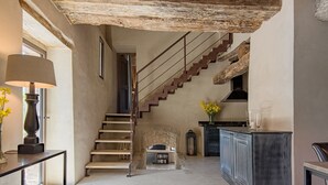 A spacious living area with a staircase, a fireplace, and a kitchen area. - Luxury villa inside a splendid estate (Perugia)
