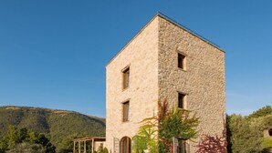 Un edificio de piedra con tres ventanas y un pequeño porche.