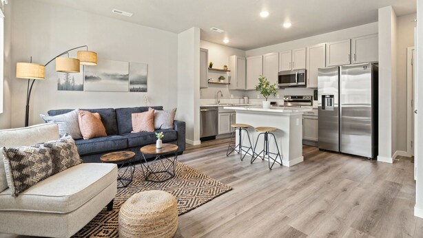 A modern kitchen with white cabinets, stainless steel appliances, and a central island. - Trendy Townhome 20 minutes to Fort Collins, Greeley, and Windsor (Ault)