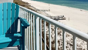 A turquoise chair and white railing overlooking a beach with a wooden walkway. - Perdido Skye Beach Front Condo | King Bed/Bunk Quarters | Gulf Front Views | Private Balcony | Pool (Pensacola)