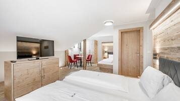 Een moderne hotelkamer met een groot bed, een televisie en een houten garderobe.