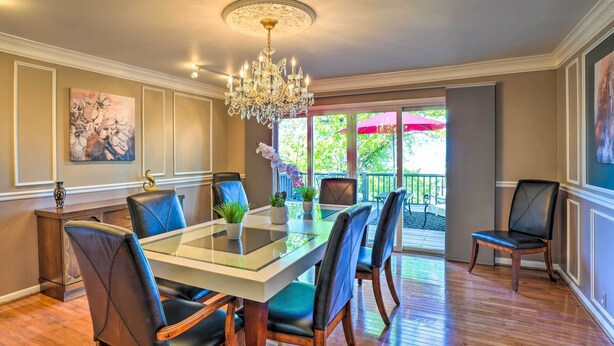A dining area with a glass-top table, six chairs, a chandelier, and a view of the outdoors. - Bring Your Pets! Chattanooga Home w/ Dtwn Views (Chattanooga)