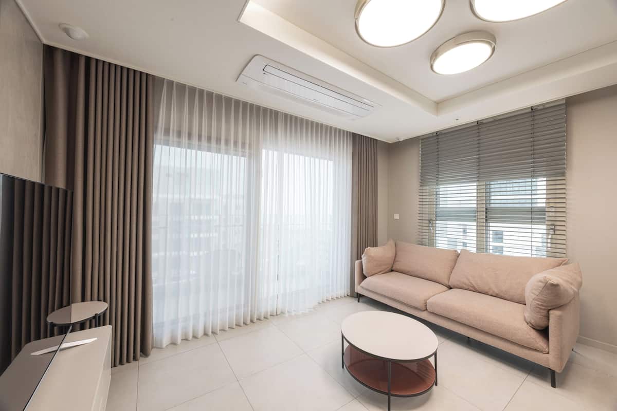Phòng Suite dành cho gia đình, quang cảnh một góc biển | Khu phòng khách | TV 65-inch có truyền hình kỹ thuật số 