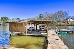 Enjoy serene lake views from this dock with a covered deck and a small boat at your disposal.